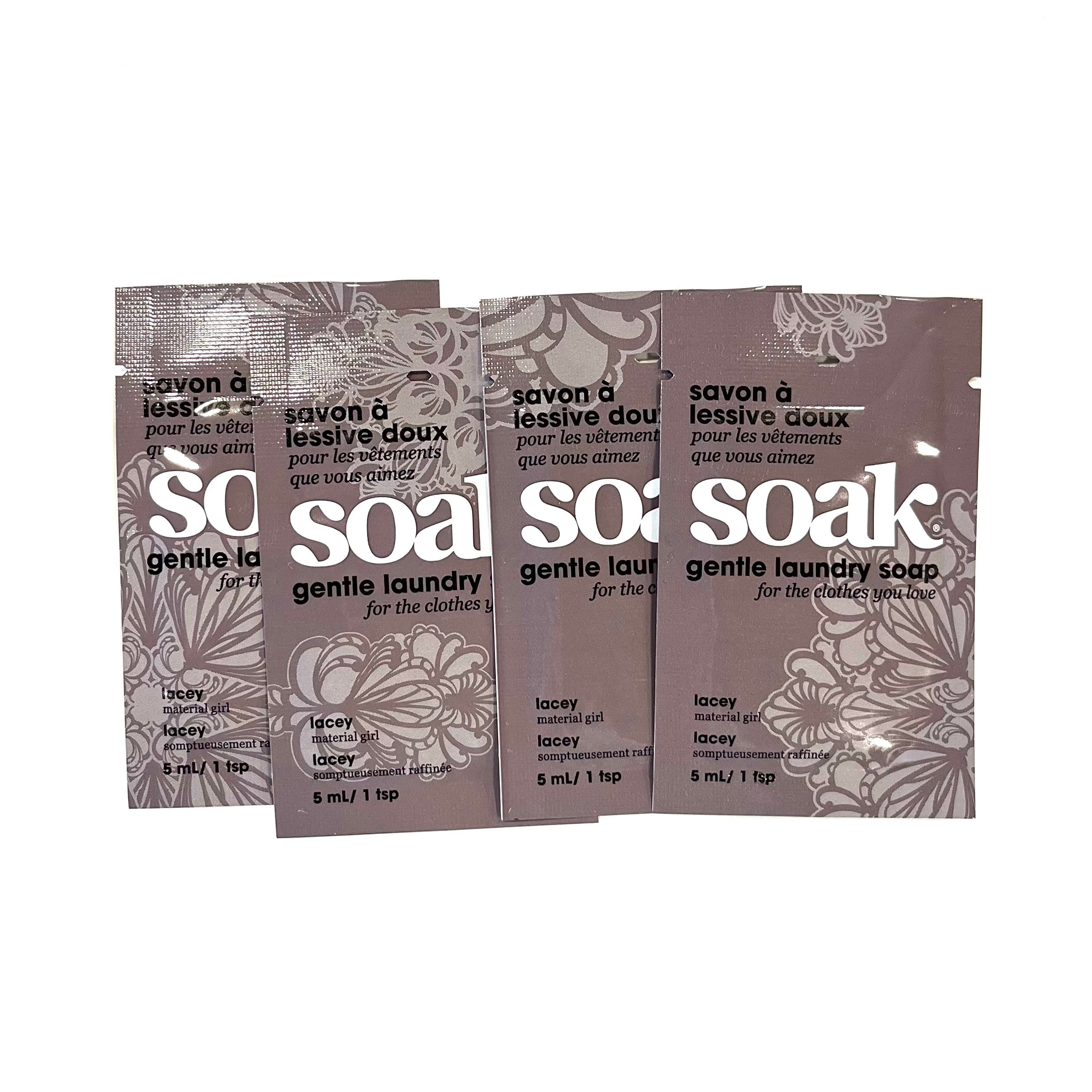 Four mini-size packets of Soak Lacey gentle laundry soap on a white background