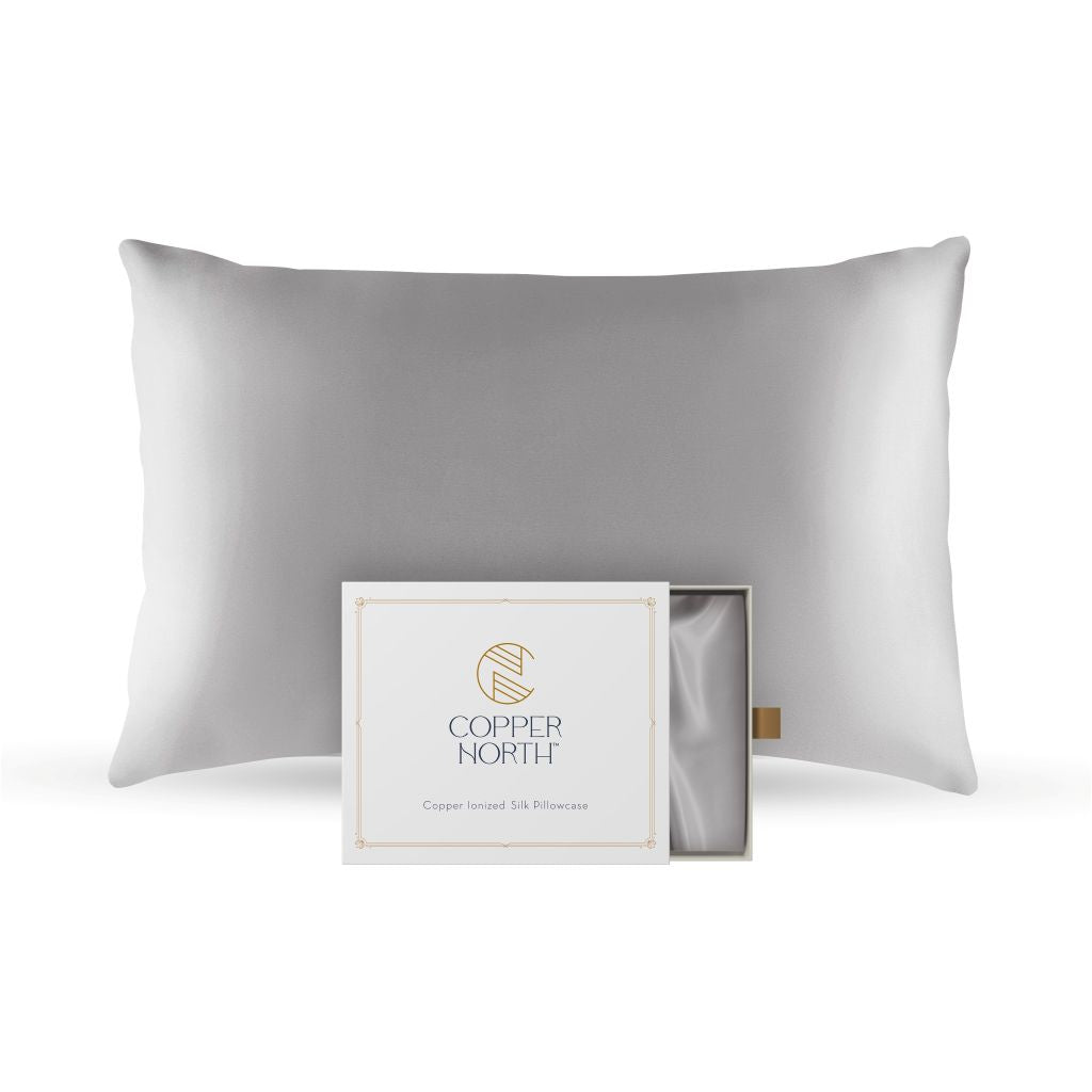 Pearl gray silk pillowcase with packaging displaying 'Copper North' brand on a white background