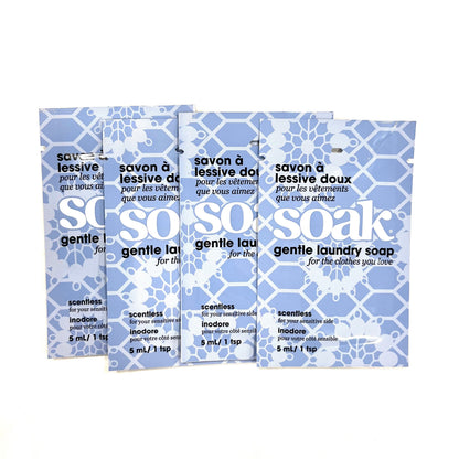 Four mini-size packets of Soak Scentless delicate laundry soap on a white background