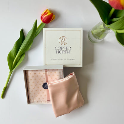 Copper North silk pillowcase with a tulip on a white surface