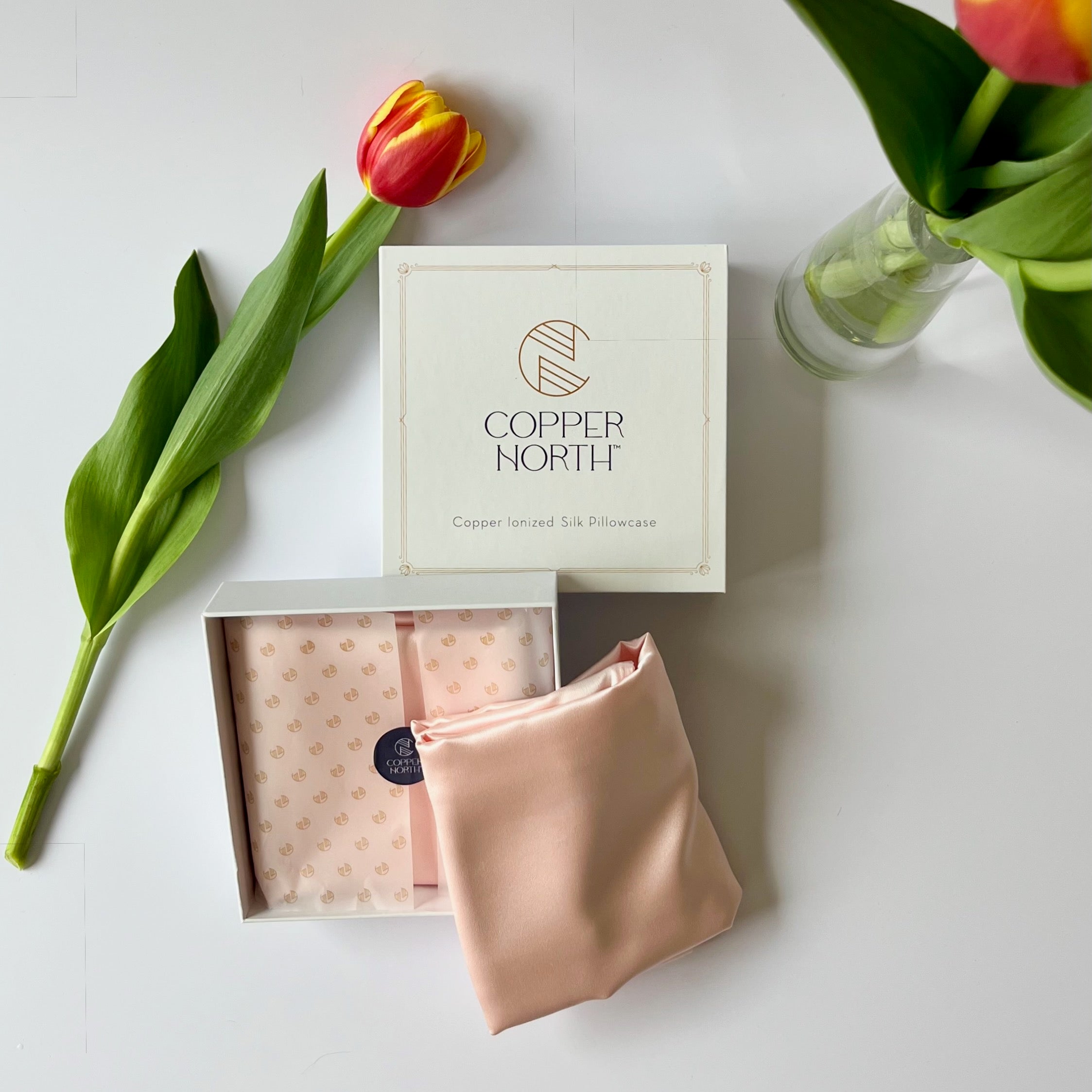 Copper North silk pillowcase with a tulip on a white surface